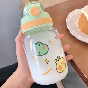 Close-up of a cute glass water bottle with colorful cartoon frog and rabbit stickers.