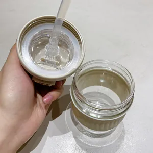 Vue détaillée montrant l'intérieur de la tasse à café en verre et le couvercle à paille