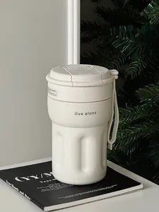 Detail shot of cream-colored insulated coffee mug with 'live alone' engraving.