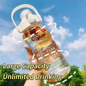 Large capacity outdoor water bottle with time markers and straw held against blue sky