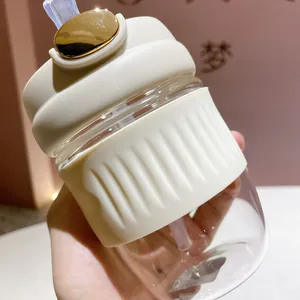 Gros plan d'un gobelet en verre avec paille et couvercle à bouton doré élégant