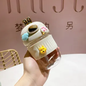 Gros plan d'un gobelet en verre de lapin mignon avec détail de breloque Winnie l'Ourson