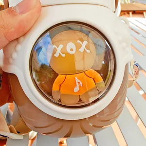 Gros plan d'une poupée de dessin animé dans le dôme d'une bouteille d'eau en acier inoxydable