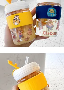 Close-up of cute glass coffee cups with cartoon stickers and silicone heat sleeves