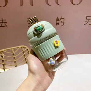 Détail d'une bouteille en verre vert menthe avec oreilles de lapin et décors cartoon