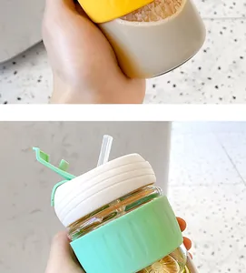 Detailed view of a minimalist glass coffee cup with a colorful silicone sleeve and straw.