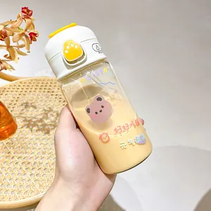 Close-up detail of a cute cartoon straw water bottle with bear stickers and yellow flip lid