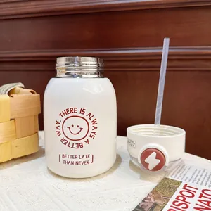 Close-up of white stainless steel water bottle with red smiley face and straw.