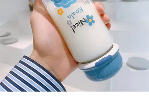 Close-up of a hand holding a cute glass water bottle with flower and koala print decorations.