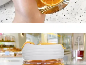 Close-up detail of a stylish minimalist glass coffee cup with a yellow and white lid