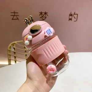 Gros plan d'une tasse en verre rose avec paille et motif lapin mignon