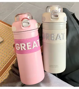 Close-up of pink and cream insulated water bottles with embossed GREAT silicone sleeves
