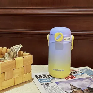 Close-up of gradient purple and yellow stainless steel thermos bottle on a newspaper