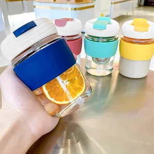 Portable glass coffee cup with colorful silicone sleeve and straw for home and office