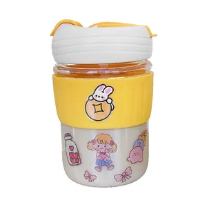Cute portable glass coffee cup with yellow silicone sleeve and cartoon stickers.