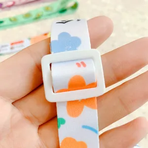 Gros plan d'une sangle de gourde à fleurs mignon avec une boucle de réglage blanche.