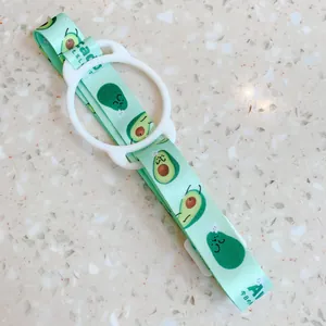 Vue détaillée d'une sangle de gourde à motif avocat mignon avec anneau en silicone blanc