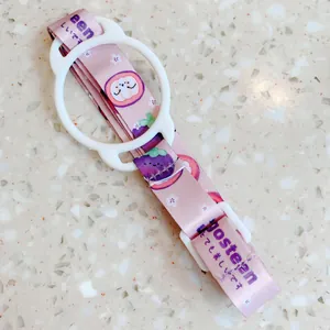 Vue détaillée d'une bandoulière rose pour bouteille avec anneau en silicone flexible