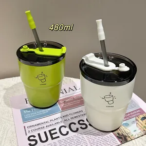 Close-up view of 480ml stainless steel coffee cups in green and white with metal straws