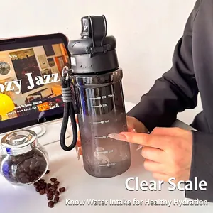 Rauchgraue Sport-Trinkflasche mit Skala und Trageschlaufe auf einem Schreibtisch