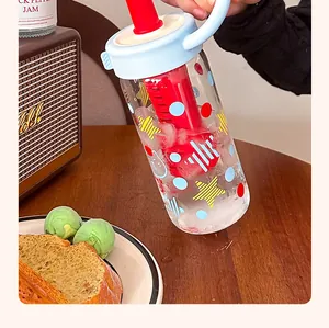 Nahaufnahme einer Glasflasche mit Eiswasser und einem auffälligen roten Tee-Siebeinsatz