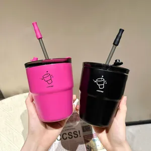 Detail of two minimalist stainless steel coffee cups with straws in pink and black colors.