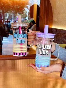 Deux verres élégants avec poignée, paille et imprimé Relaxed Time pour le bureau.