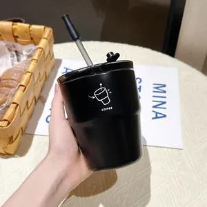 Close-up of minimalist black stainless steel coffee cup with straw and lid in a cozy setting