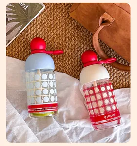 Detailed view of creative borosilicate glass water bottles with straw and red ball caps