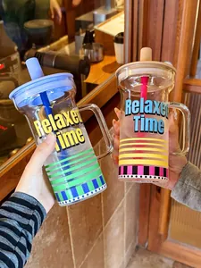 Deux grands verres élégants avec poignée et paille dans un décor de café chaleureux