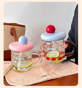 Close-up of cute glass straw cups with handles and colorful lids for home or office