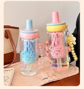 Close-up of colorful glass water bottles with straw and tea filter in a lifestyle setting