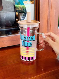 Gros plan d'un verre avec anse et texte 'Relaxed Time', tenu par une main féminine.