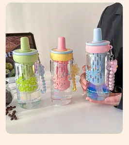 Detailed view of three colorful pastel straw water bottles with tea filters and straps.