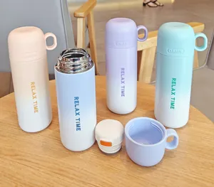 Primer plano de cuatro termos de acero inoxidable con degradado y tapas de taza