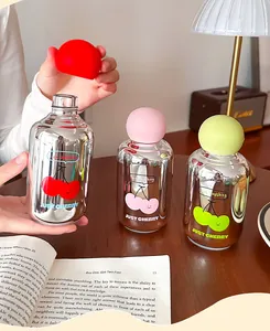 Gros plan sur des bouteilles en verre miroir avec motifs cerises en trois couleurs.