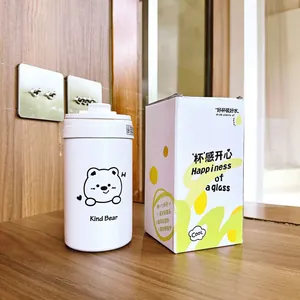 Detailansicht einer weißen Thermo-Wasserflasche mit Bär neben der gelben Schachtel.