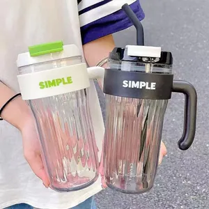 Close-up of black and white minimalist plastic tumblers with straws and handles.