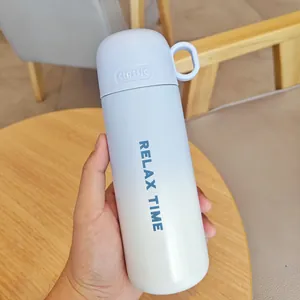 Botella térmica de acero inoxidable con degradado azul y texto RELAX TIME sostenida a mano