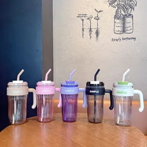Detailed view of colorful minimalist straw cups with handles on a wooden table