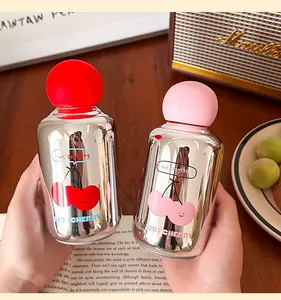 Gros plan de jolies bouteilles d'eau en verre miroir avec motif cerise et bouchons