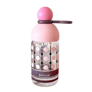Pink high-borosilicate glass water bottle with built-in straw and decorative dot pattern
