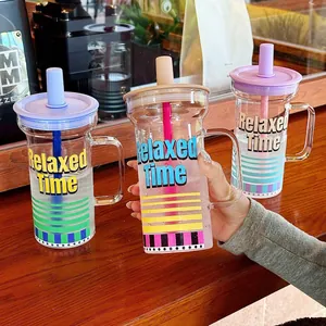 Grande tasse en verre avec poignée et paille et motif à rayures colorées