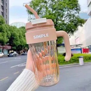 Close-up of a stylish pink minimalist straw cup held in hand against a street backdrop