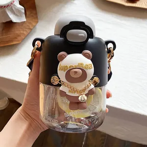 Detalle de una taza de plástico negra con tema de oso y cadena dorada