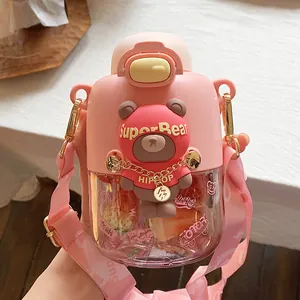 Primer plano de una linda botella de agua rosa para niños con diseño de oso y correa ajustable.
