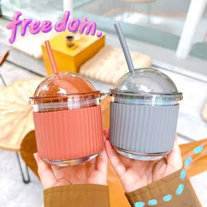 Close-up of two cute egg-shaped glass straw cups with colorful silicone sleeves