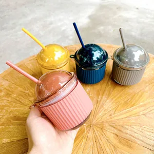 Macro view of a cute egg-shaped glass cup with a colorful straw and silicone sleeve.