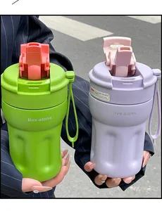 Detailed view of portable insulated coffee tumblers with straw in vibrant green and purple