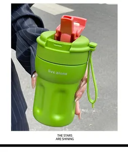Detailed close-up of a vibrant green portable coffee cup featuring a red straw lid